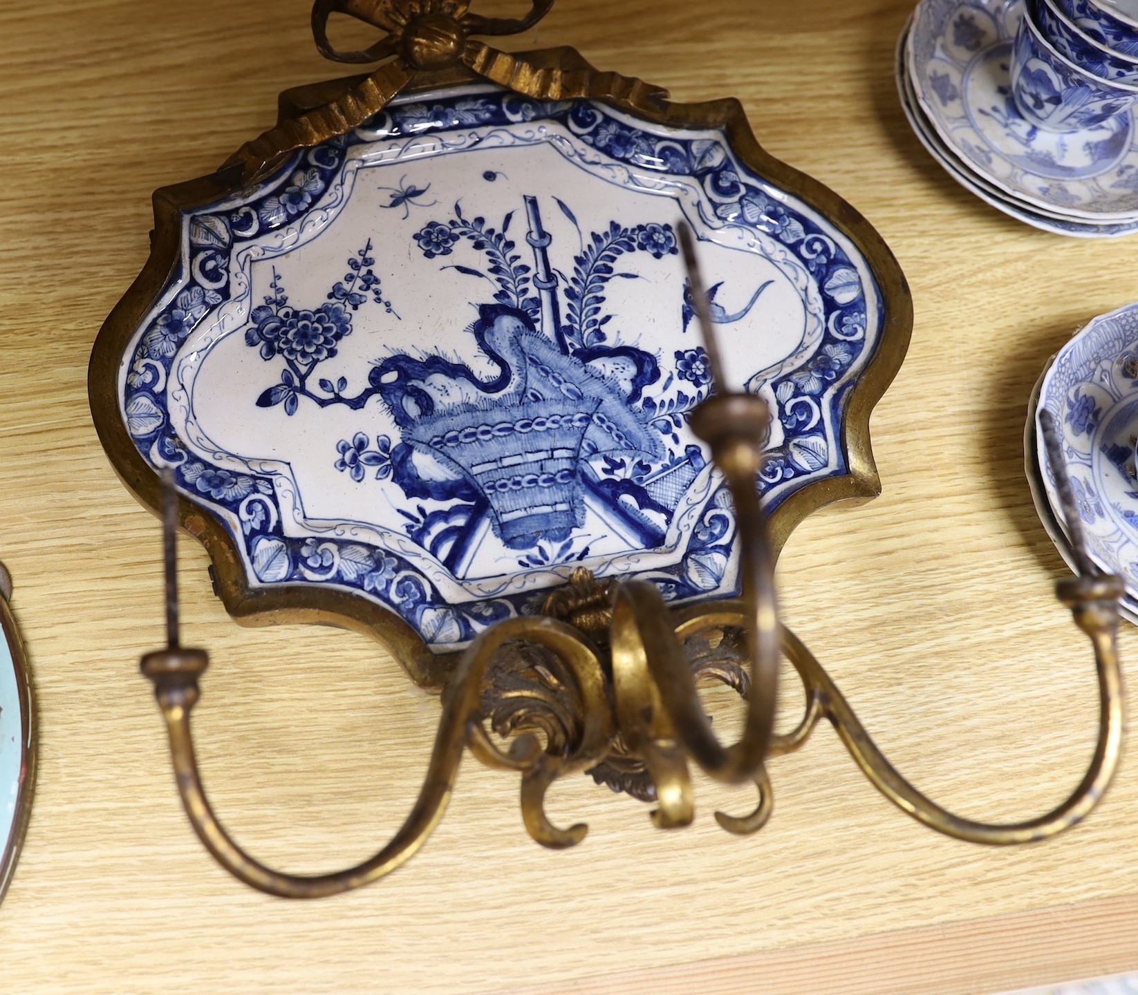 A pair of 19th century ormolu blue and white Delft wall sconces and with blue and white Chinese tea bowls and saucers forming the drip pans